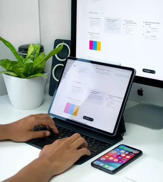 Modern Workspace with Tablet and Smartphone Person using a tablet and keyboard in a modern workspace